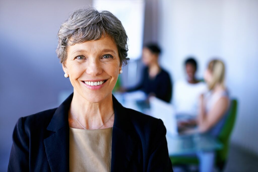 Real estate mature woman realtor smiling at brokerage office